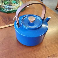 Side view of blue enamel teakettle showing wood handle and knob