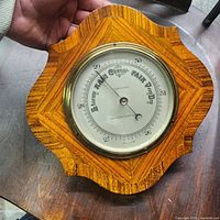Front view of barometer on decorative wood plaque