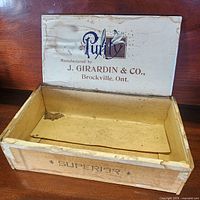 Open cigar box showing interior printing and wear