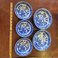 Five Blue Willow bowls with ruler for scale