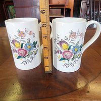 Front view of both mugs with floral design and ruler for scale