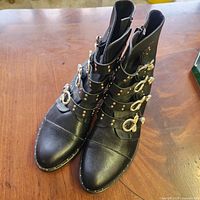 Boots front and angled view showing straps, buckles, studs