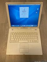 Laptop open showing display running Mac OS X 10.3.5 desktop