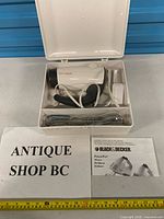 Open storage case with mixer, attachments and manual visible