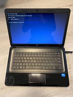Front view of powered-on HP 2000 laptop showing keyboard, touchpad and error screen