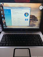 Laptop powered on showing Windows Vista system screen