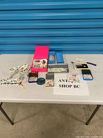 Overall lot on table showing tins, boxes, pouches filled with tattoos and stickers