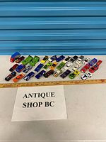 All 32 Hot Wheels vehicles laid out with ruler for scale