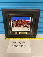 Full view of framed Team Canada Sochi 2014 gold medal photo with measuring tape for scale