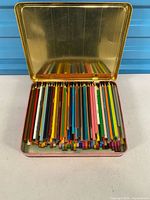 Open metal tin showing full assortment of colored pencils