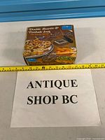 Box front with branding and set imagery next to tape measure