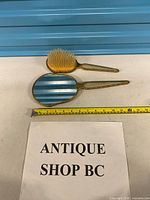 Mirror and brush pair on table with measuring tape