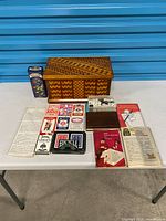 Group shot of wooden box, card decks, dice, marbles tin, score pads