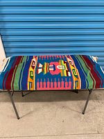 Textile covering bench viewed from front; shows pattern and bench legs