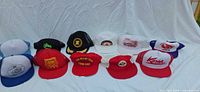 All eleven hats laid out showing fronts and brims