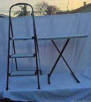 Stool and table unfolded side by side against backdrop