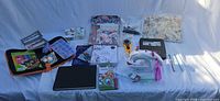 Full lot overview showing sewing machine, pyrography kit, papers, fabrics, tools