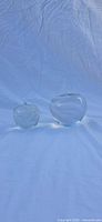 Both glass apple paperweights side by side