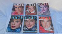 Six Vogue magazines laid out in two rows