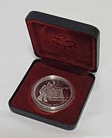 Coin reverse showing hockey design in open case