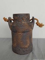 Front view of cylindrical fat lava vase showing texture and rope handles