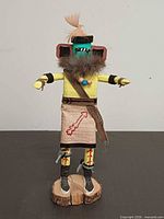 Front view showing full figure, paint, fur collar, cloth kilt and base