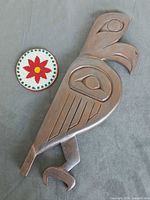 Front view of carved bird wall totem and beaded medallion
