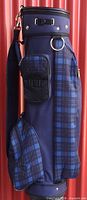 Left side view of Knight golf bag showing plaid panels, pockets, shoulder strap attachment