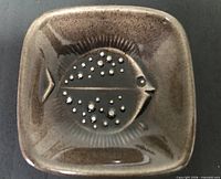 Top view of square brown glazed ceramic dish with fish motif