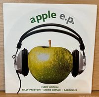 Front of picture sleeve displaying apple with headphones