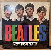 Front cover with Beatles portraits and multicolour title under shrink wrap