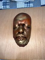 Front view of metallic bronze-gold life mask of Ringo Starr