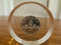 Front view of resin-encased 1959 Canadian Voyageur dollar