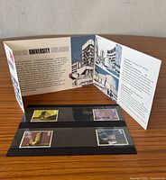 Front view of open presentation pack showing descriptive card and two of the mounted stamps