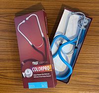 Stethoscope in original open box showing light blue tubing and chrome parts next to product packaging