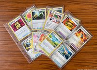 Spread of 16 Trainer cards in binder sleeves