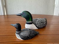 Side view of both loon decoys on tabletop