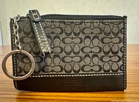Front view of Coach Mini ID Skinny wallet showing key ring, canvas pattern and leather trim