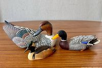 Front three-quarter view of all three decoys showing size relation and paint detail