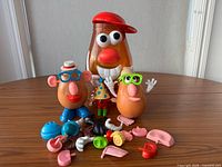 Front view of storage container, 2 potato bodies, loose accessories spread in front