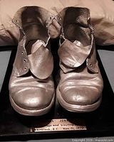 Front view of silver combat boots trophy on base
