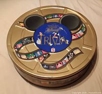Top view of round gold tin showing Disney Trivia Game branding and design