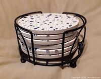 Coasters stacked in black wire rack