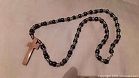 Full view of beaded crucifix necklace showing wooden cross pendant and bead pattern
