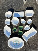 Overhead view of all fourteen ceramic pieces laid out on ground