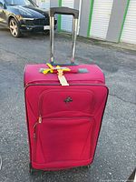 Full front view of red/fuchsia Atlantic upright suitcase with extended handle