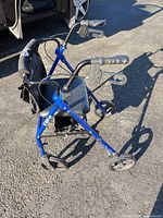 Side view of metallic blue Elite rollator showing frame, wheels, brakes, seat, under-seat bag