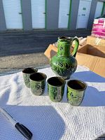 Set showing pitcher and four cups on cloth