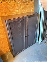 Front view of closed cabinet showing dark brown veneer and two doors