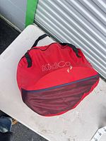Red KidCo circular carry bag top view showing logo